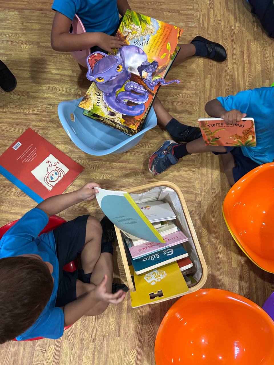 Niñas y niños explorando libros de manera independiente en una sesión de Rincón de Historias